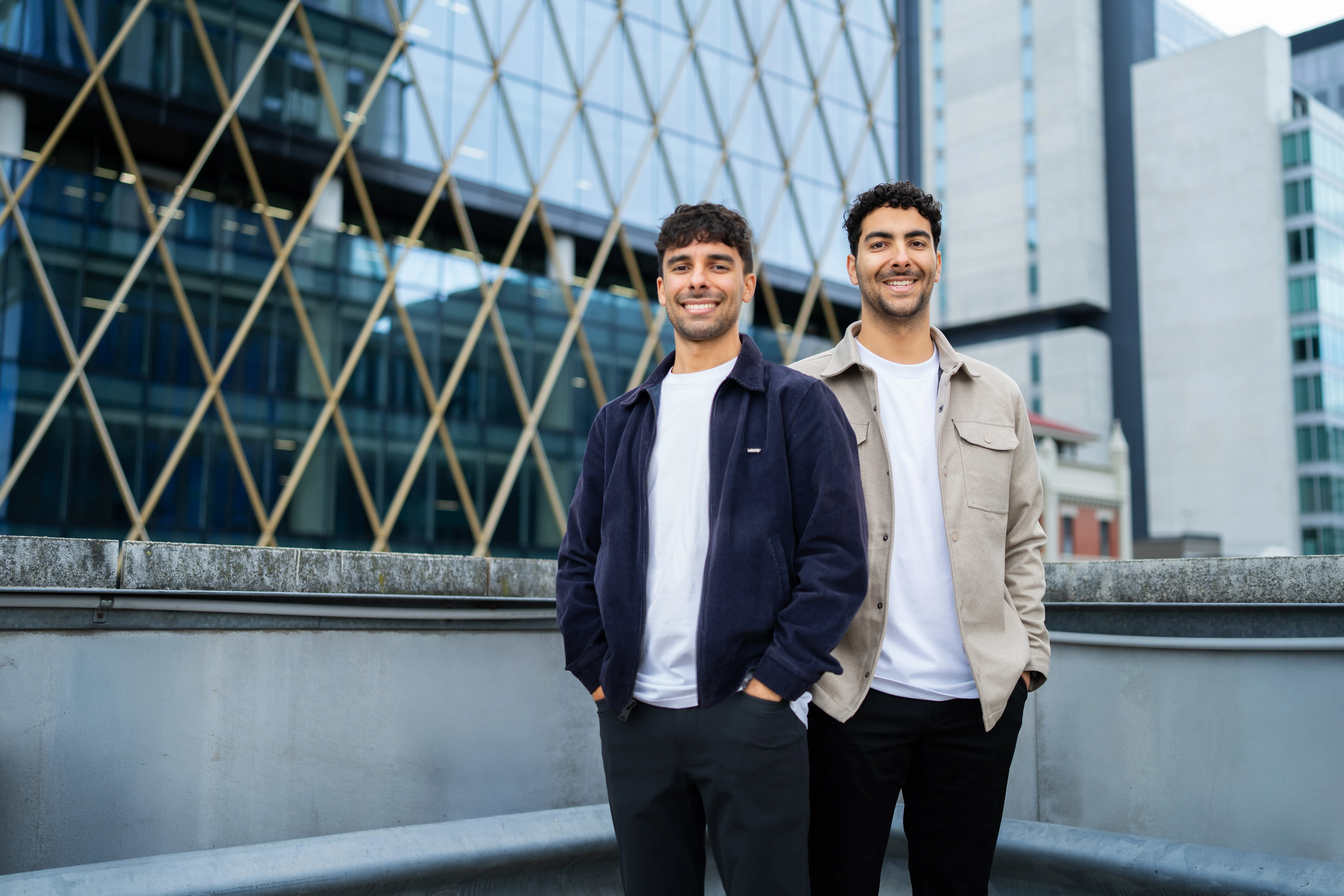 Sav and Dom smiling on top of a skyscraper
