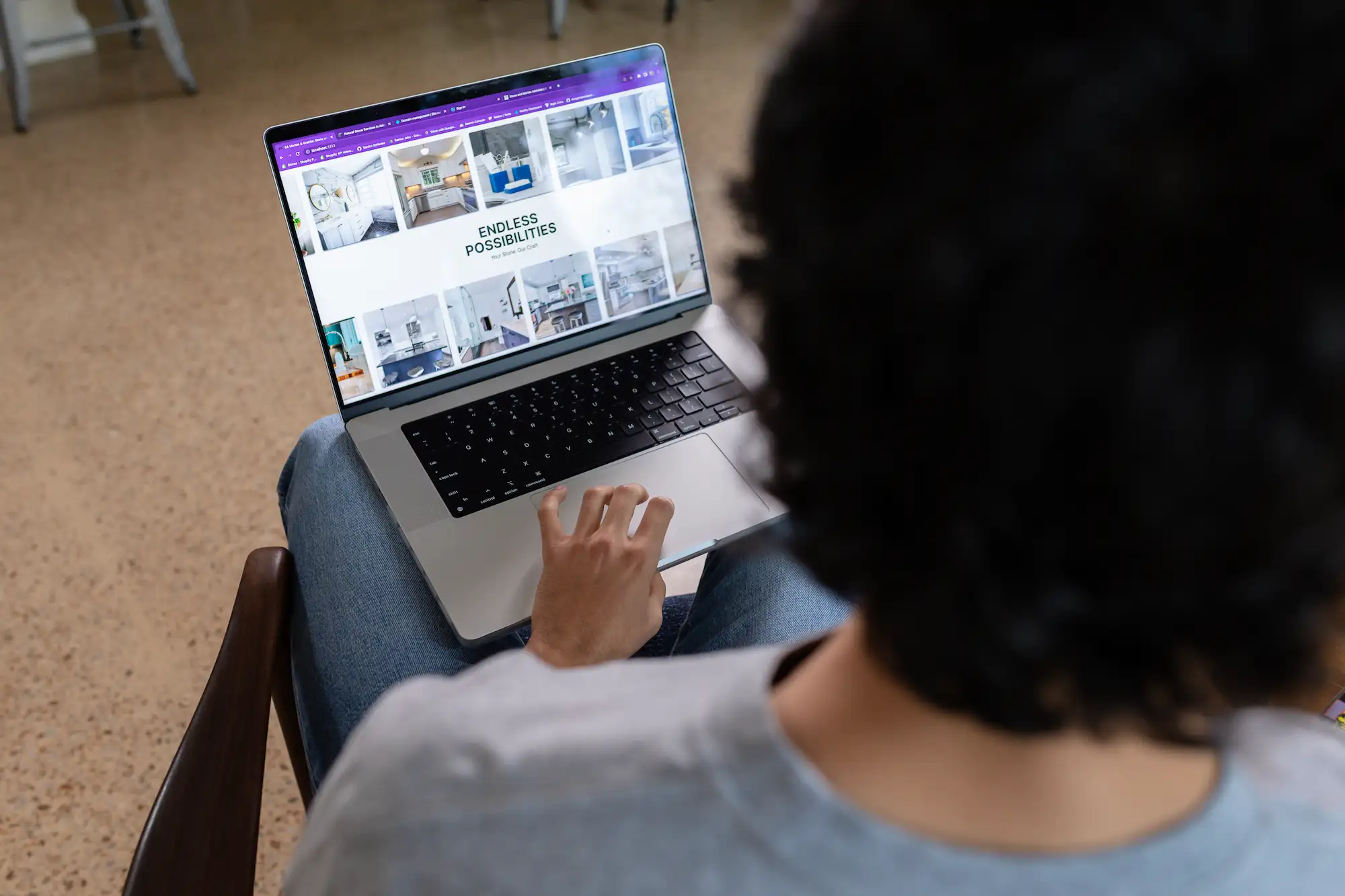 Sav holding laptop showing SA Marble & Granite Website Home Page.