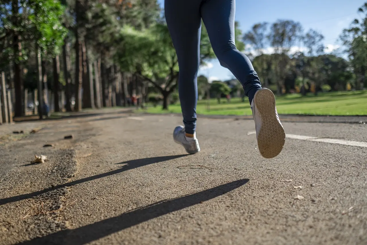 Woman running on road in running outfit.